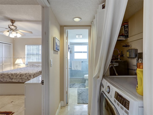 laundry area with ceiling fan, a textured ceiling, and washer / clothes dryer