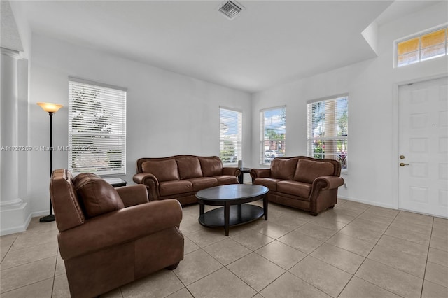 living room featuring ornate columns and light tile patterned floors