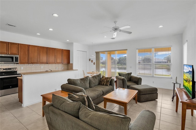 living room featuring ceiling fan, plenty of natural light, and light tile patterned flooring