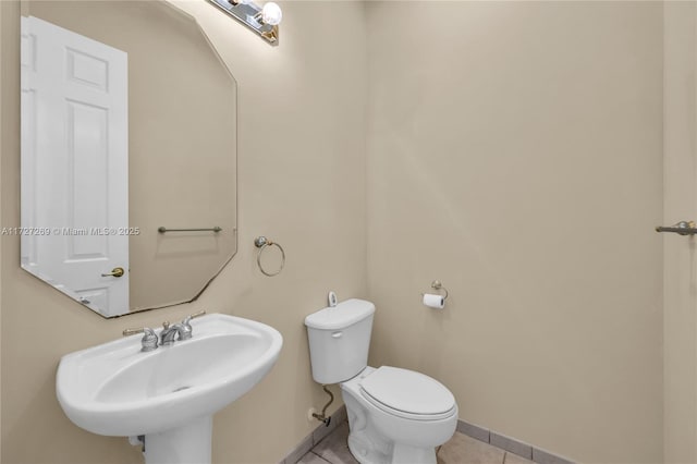 bathroom featuring toilet, tile patterned flooring, and sink