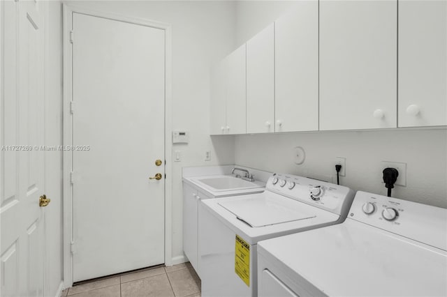 laundry room with cabinets, light tile patterned floors, separate washer and dryer, and sink