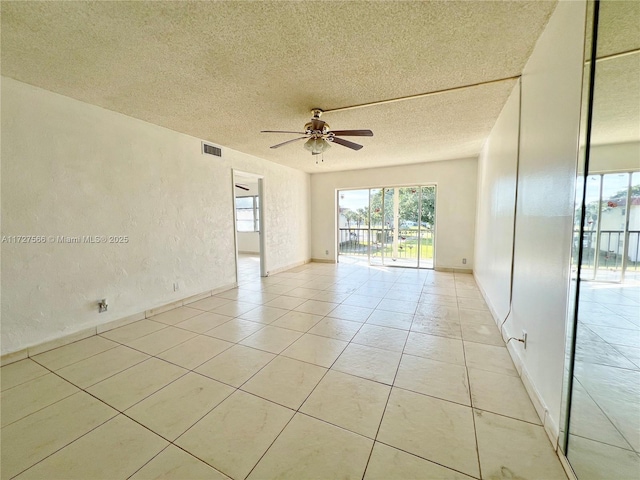 tiled spare room with ceiling fan and a textured ceiling