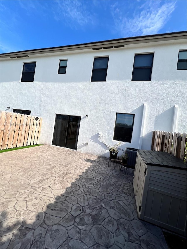 rear view of house with a patio area and cooling unit