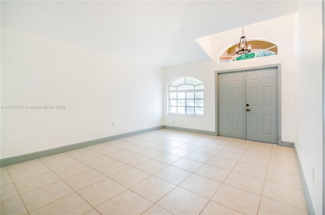 entryway with light tile patterned floors and a chandelier