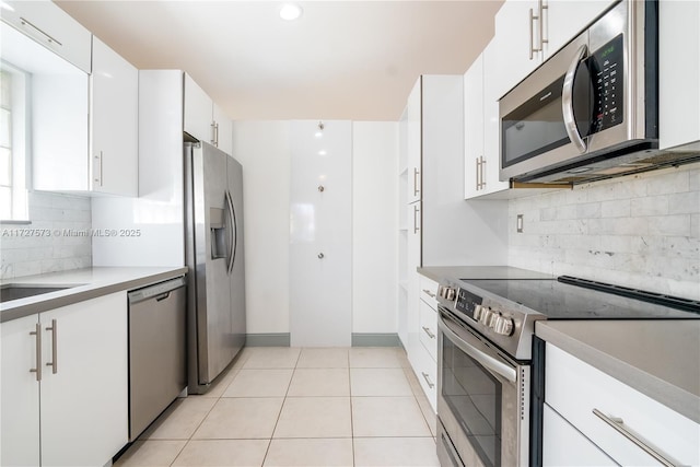 kitchen with light tile patterned flooring, stainless steel appliances, white cabinetry, and sink