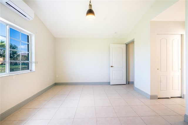 tiled spare room with a wall unit AC