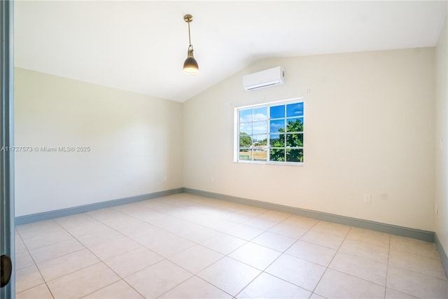 empty room featuring an AC wall unit, light tile patterned floors, and vaulted ceiling