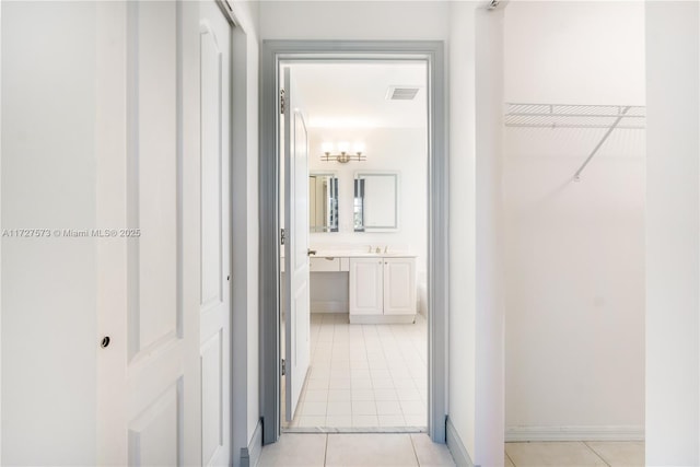 hallway with sink and light tile patterned flooring