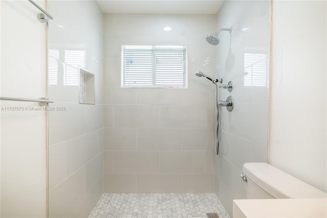 bathroom with toilet and tiled shower