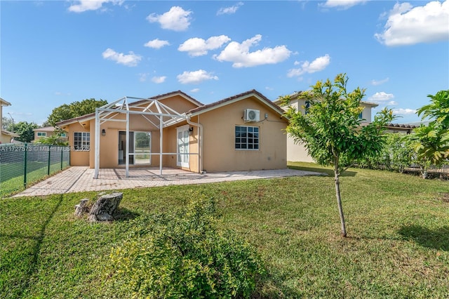 rear view of house featuring glass enclosure, a yard, and a patio