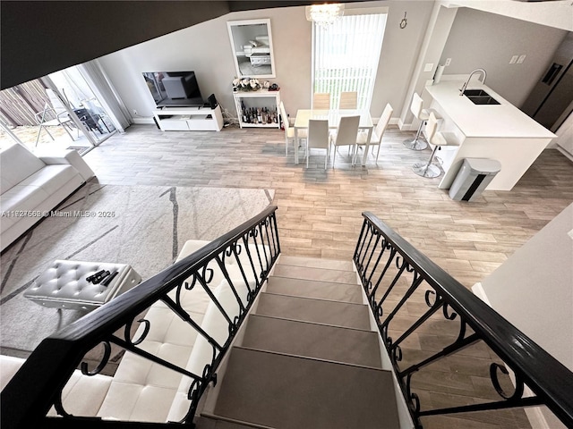 living room featuring sink, a chandelier, and hardwood / wood-style flooring