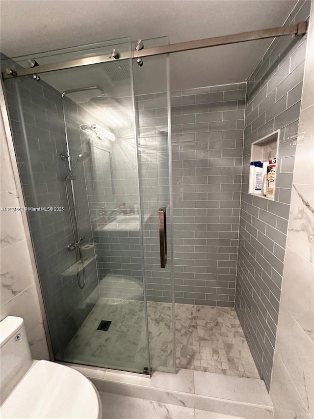 bathroom featuring walk in shower and toilet