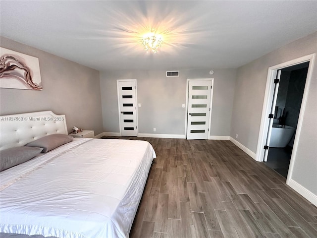 bedroom with dark wood-type flooring and ensuite bathroom