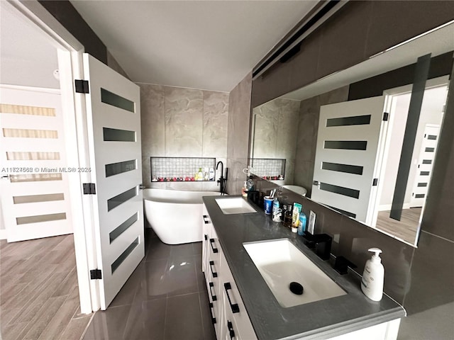 bathroom with vanity, a bathing tub, and hardwood / wood-style flooring