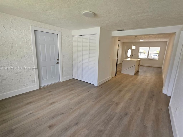 empty room with a textured ceiling and wood-type flooring