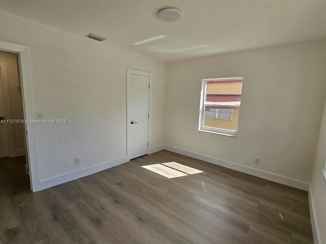 spare room featuring dark wood-type flooring