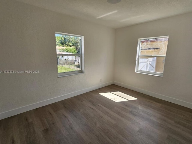 spare room with dark hardwood / wood-style flooring