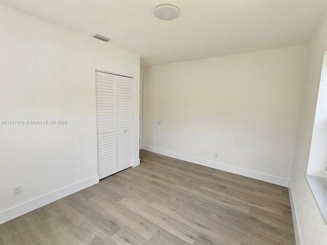 unfurnished bedroom with light hardwood / wood-style flooring and a closet