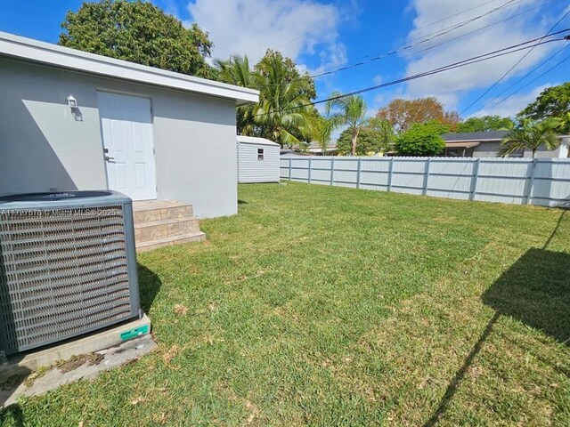 view of yard with cooling unit and a storage unit