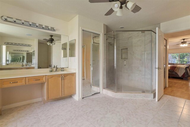 bathroom featuring tile patterned flooring, an enclosed shower, and vanity