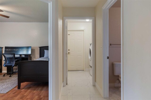 corridor featuring a textured ceiling and light hardwood / wood-style floors