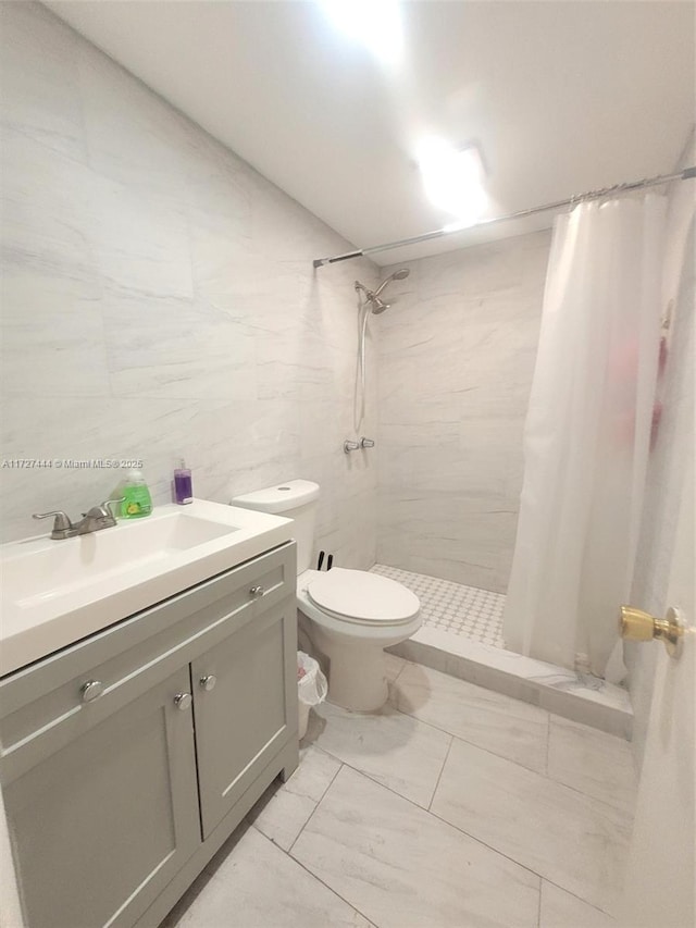 bathroom featuring toilet, vanity, tile walls, and curtained shower