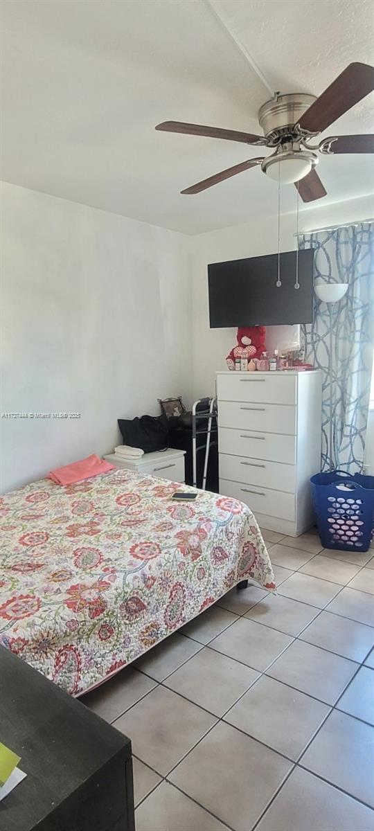 bedroom featuring ceiling fan and tile patterned flooring