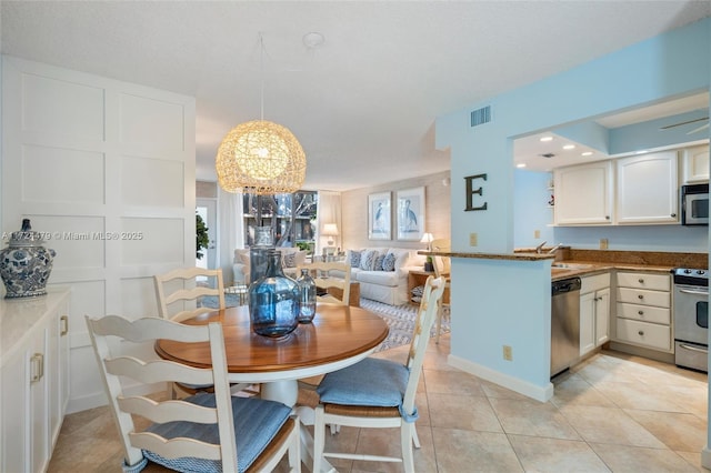 dining space featuring sink and light tile patterned floors