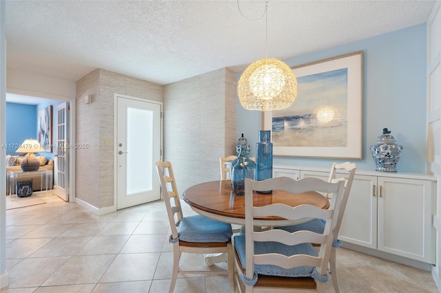 dining space with a textured ceiling and light tile patterned flooring