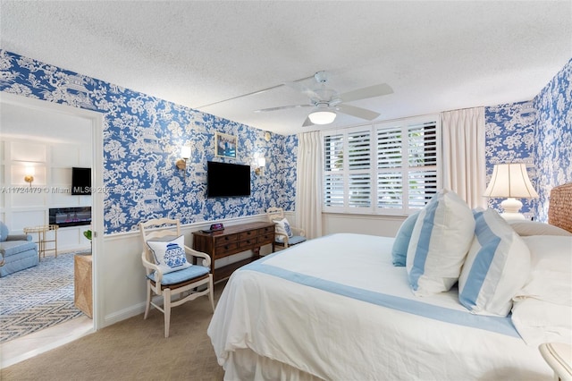 carpeted bedroom featuring ceiling fan and a textured ceiling