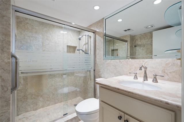 bathroom featuring a shower with door, toilet, vanity, and tasteful backsplash