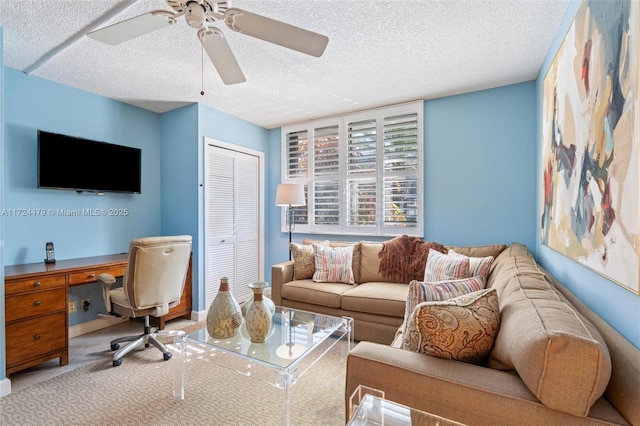 carpeted living room with ceiling fan and a textured ceiling