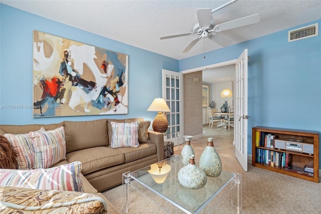 living room with ceiling fan, a textured ceiling, and french doors