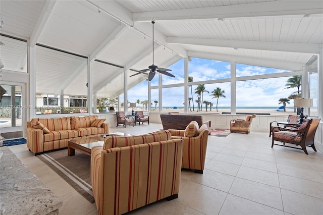 living room featuring a water view, light tile patterned floors, lofted ceiling with beams, and a healthy amount of sunlight