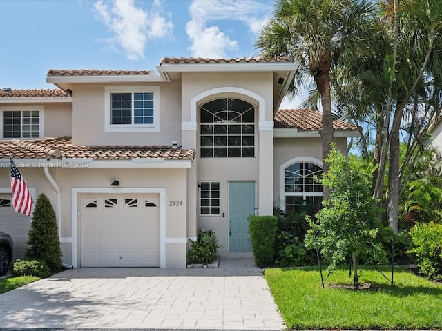 mediterranean / spanish home with a front lawn and a garage