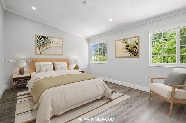 bedroom featuring crown molding, lofted ceiling, hardwood / wood-style floors, and multiple windows