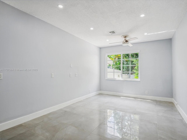 empty room featuring a textured ceiling and ceiling fan