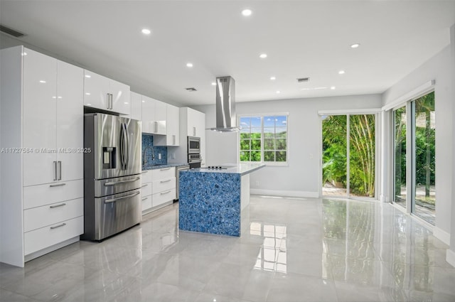 kitchen with a kitchen island, white cabinetry, island exhaust hood, stainless steel appliances, and decorative backsplash