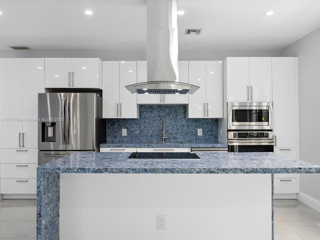 kitchen featuring a kitchen island, decorative backsplash, stainless steel appliances, white cabinets, and island range hood