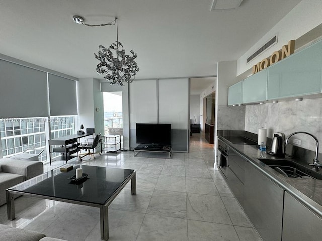 living room with a chandelier, floor to ceiling windows, and sink