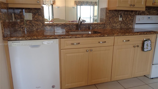 kitchen featuring dark stone countertops, decorative backsplash, sink, white appliances, and light tile patterned floors