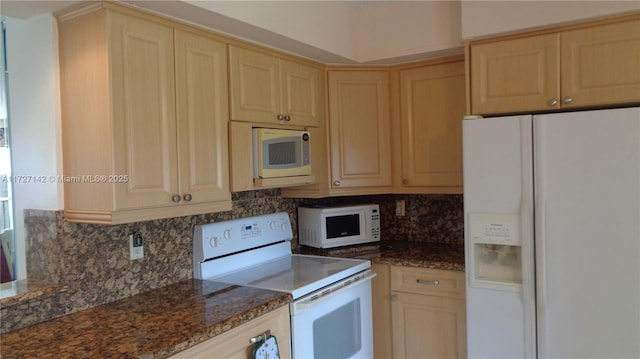 kitchen with light brown cabinetry, tasteful backsplash, dark stone counters, and white appliances