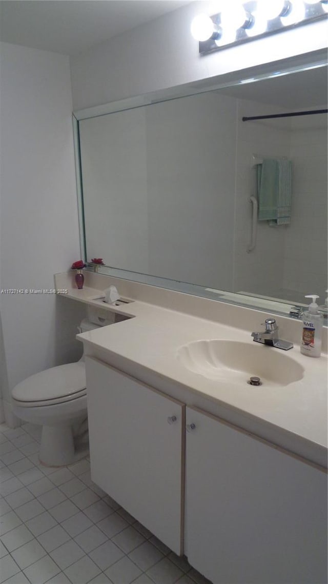 bathroom featuring toilet, tile patterned floors, and vanity