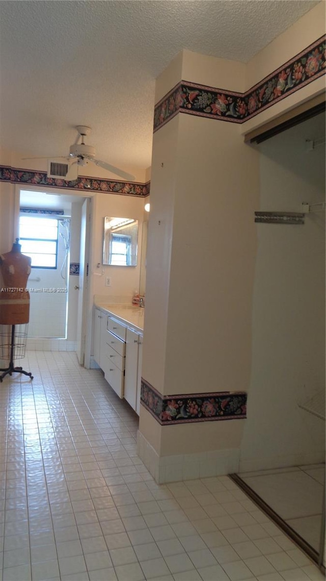 bathroom featuring ceiling fan, a textured ceiling, tile patterned floors, and vanity