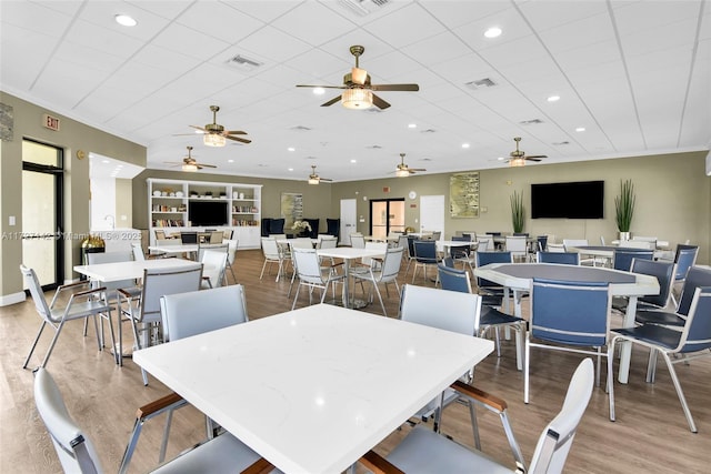 dining area with hardwood / wood-style flooring, built in shelves, and crown molding