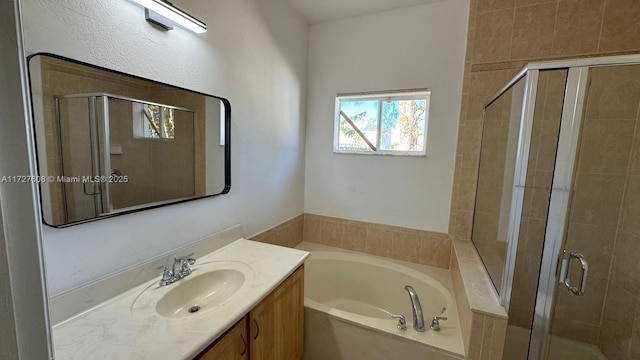 bathroom with vanity and shower with separate bathtub