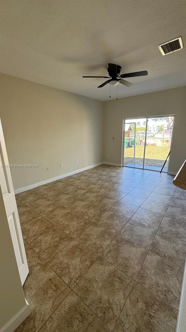 tiled spare room featuring ceiling fan