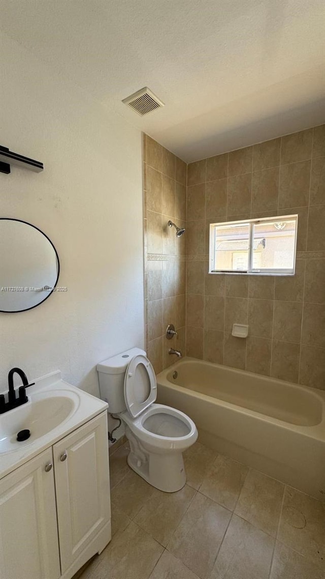 full bathroom with tiled shower / bath combo, vanity, tile patterned flooring, and toilet