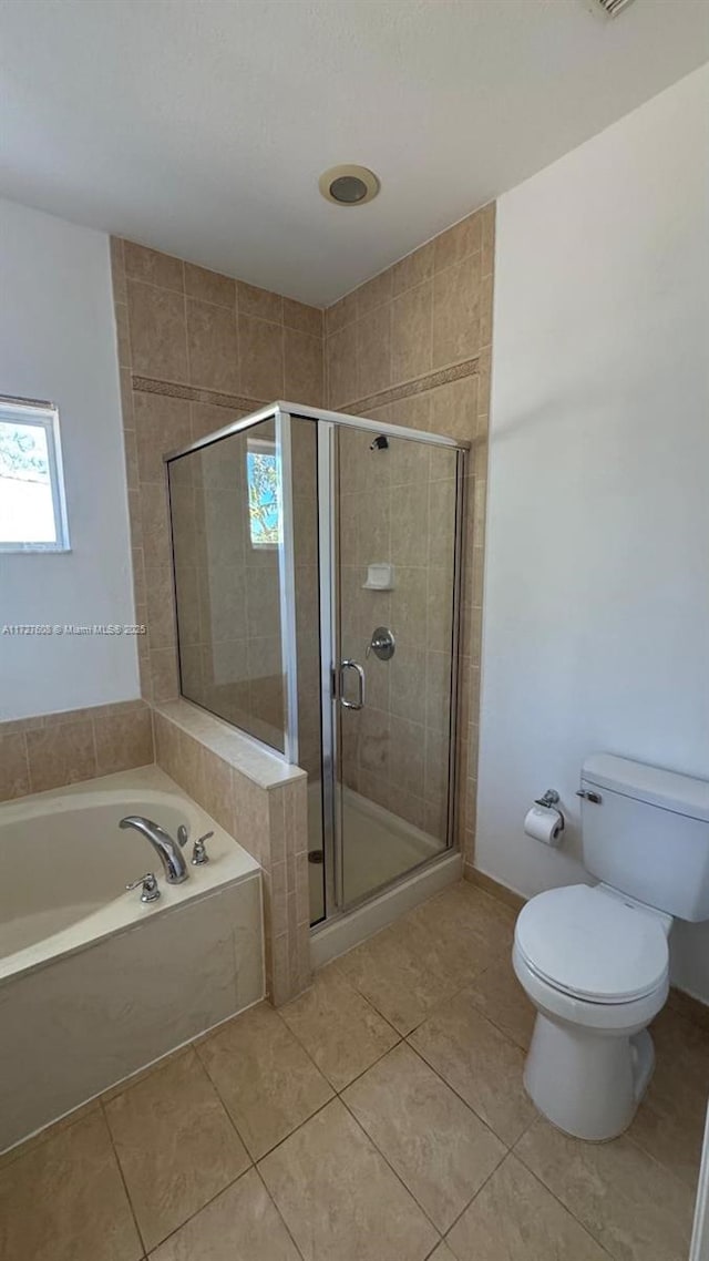 bathroom featuring tile patterned flooring, shower with separate bathtub, and toilet