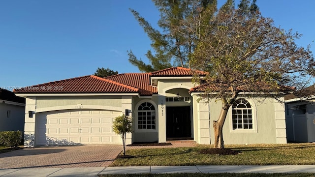 mediterranean / spanish-style house with a garage and a front lawn